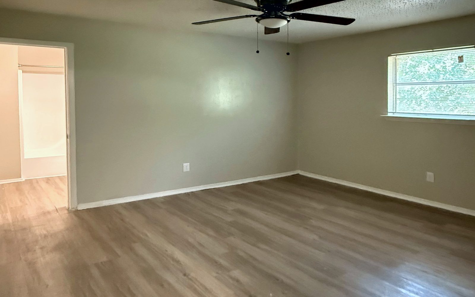 Bedroom with a ceiling fan, a window and vinyl plank floors
